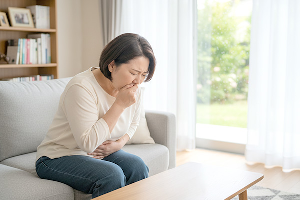 腹部をおさえる女性